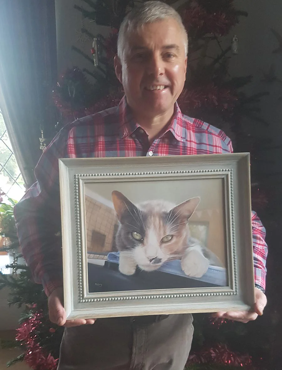 Client Andrew proudly holding Mitzy’s oil portrait on Christmas Day, a touching moment.