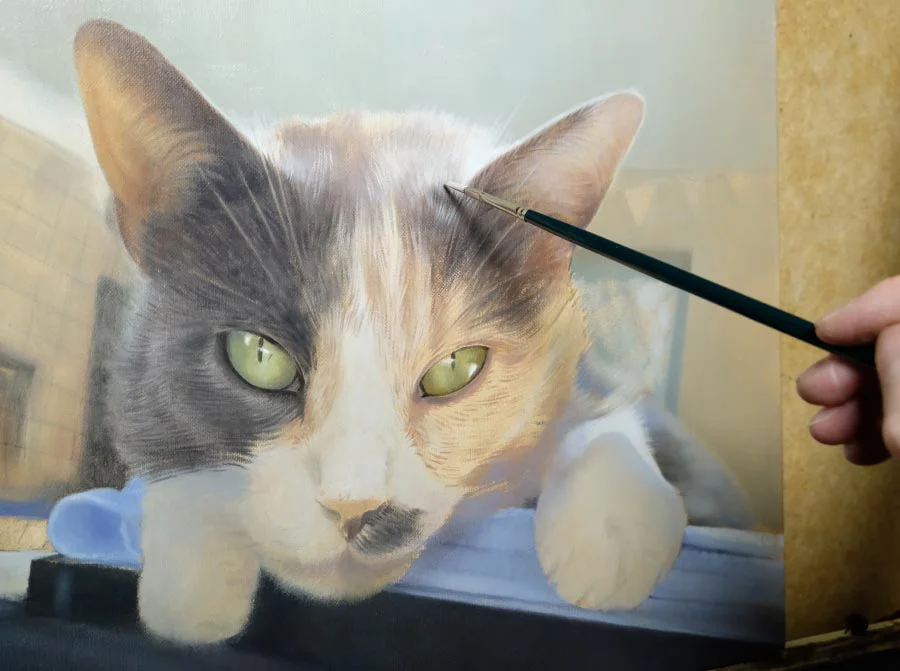 Mitzy's finished cat oil portrait displayed on an easel in the artist's studio.