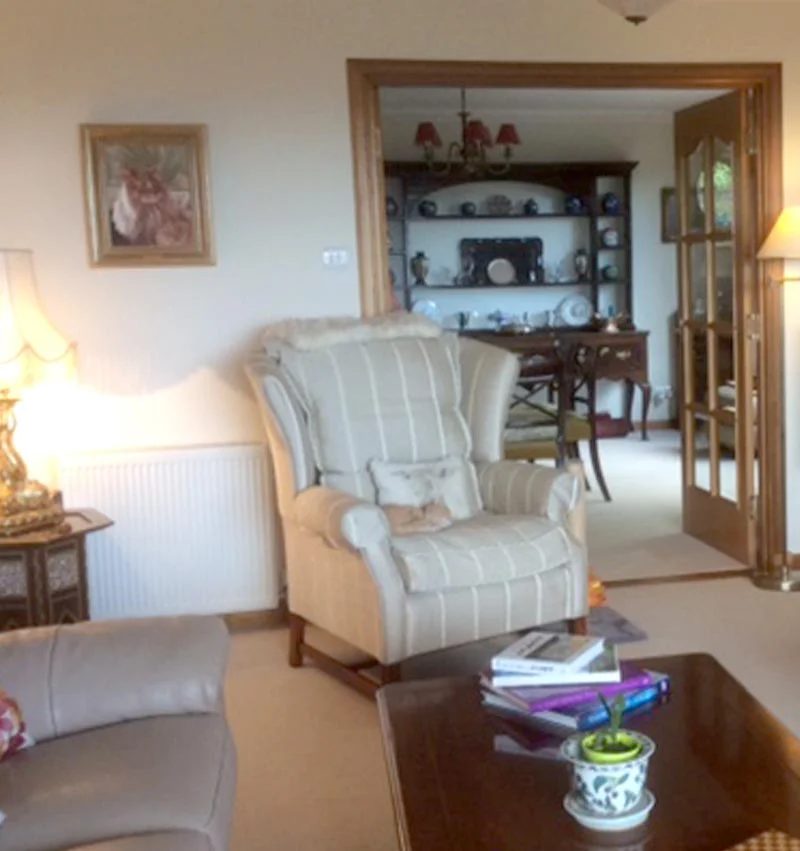 Client displaying the framed oil painting of Roly the cat, showing its new home.