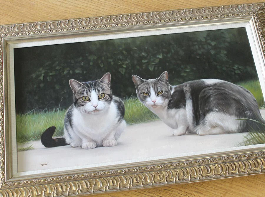 Framed cat oil painting of Milly and Molly displayed prominently on a wall.