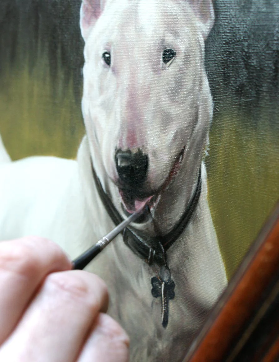 Millie the Bull Terrier's oil portrait displayed on an artist's easel.