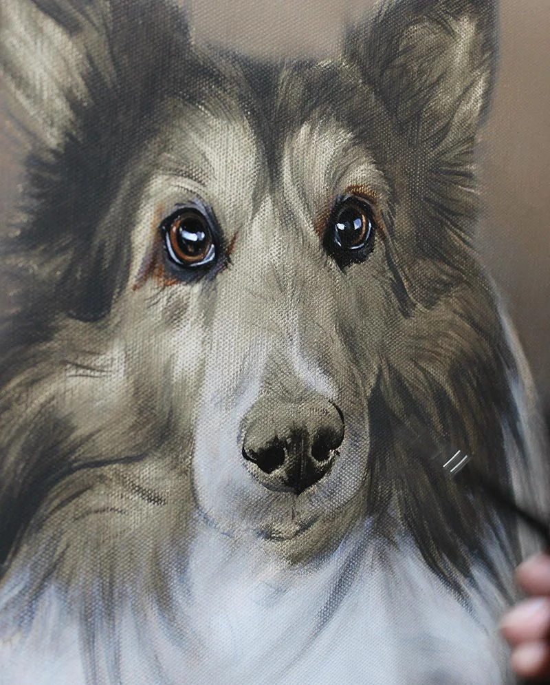 Artist layering oils on the Sheltie portrait to build depth and texture