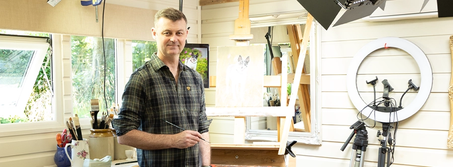 Nicholas Beall by his painting easel in his studio.