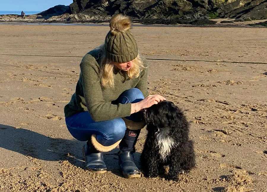 Melanie Phillips smiling next to her Tibetan Terrier, Lily.