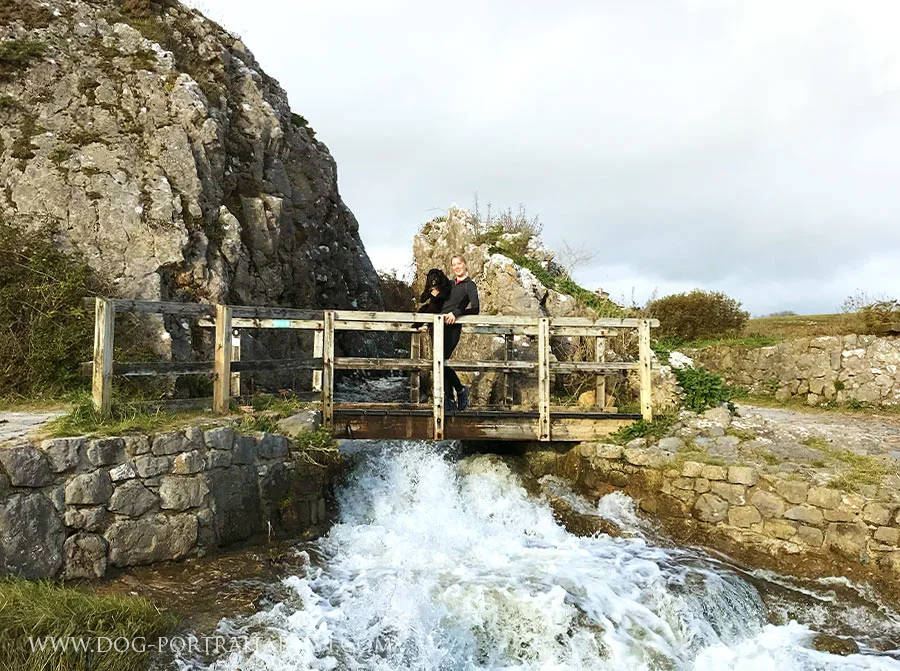 Melanie Phillips running energetically with Lily the Tibetan Terrier along the scenic coast near Stackpole, Pembrokeshire.