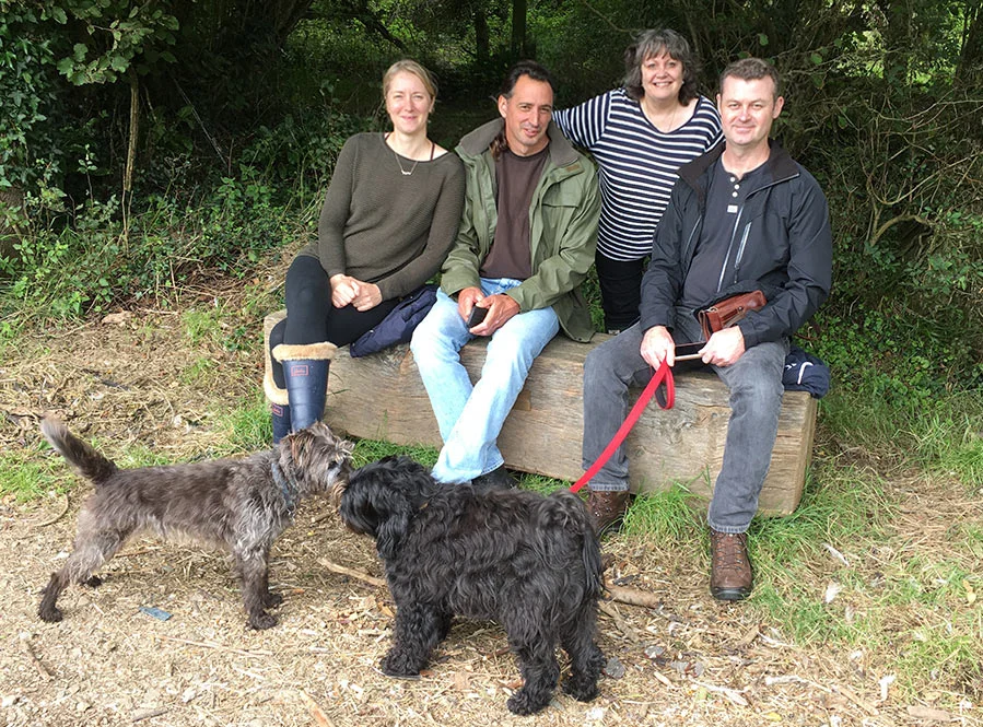 Nicholas, Melanie, and friends walking happily in the Pembrokeshire countryside with their dogs, including Lily.