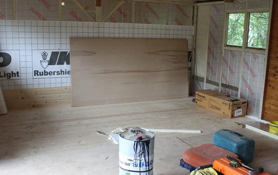 Insulating the Studio Walls Before Paneling Studio walls being fitted with insulation bats and prepared for the installation of tongue and groove wood paneling.