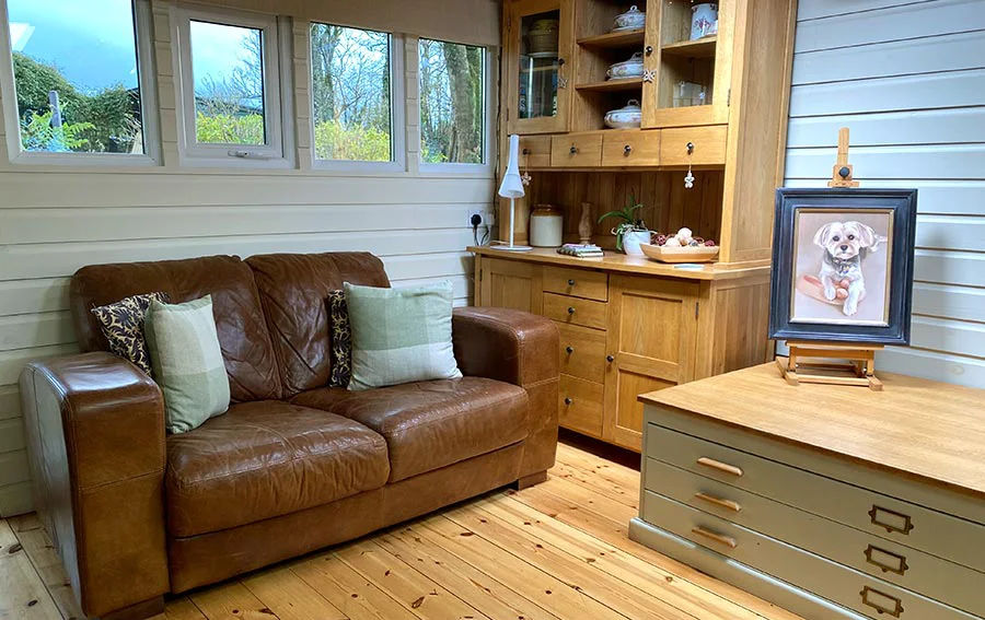 Client Seating Area and Vintage Plan Chest in the Art Studio A cozy client seating area within the art studio, featuring comfortable chairs and a vintage plan chest used for storage and packing.