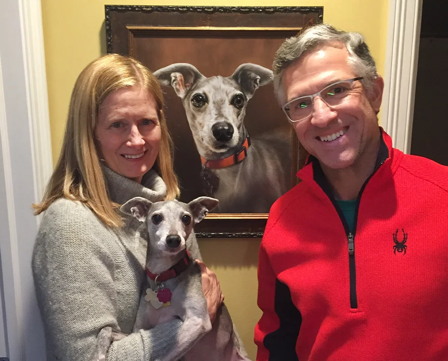 Artists with Spyder the Italian Greyhound's Portrait Artists Melanie and Nicholas posing with a newly completed oil portrait of Spyder, an Italian Greyhound, for client Karen.